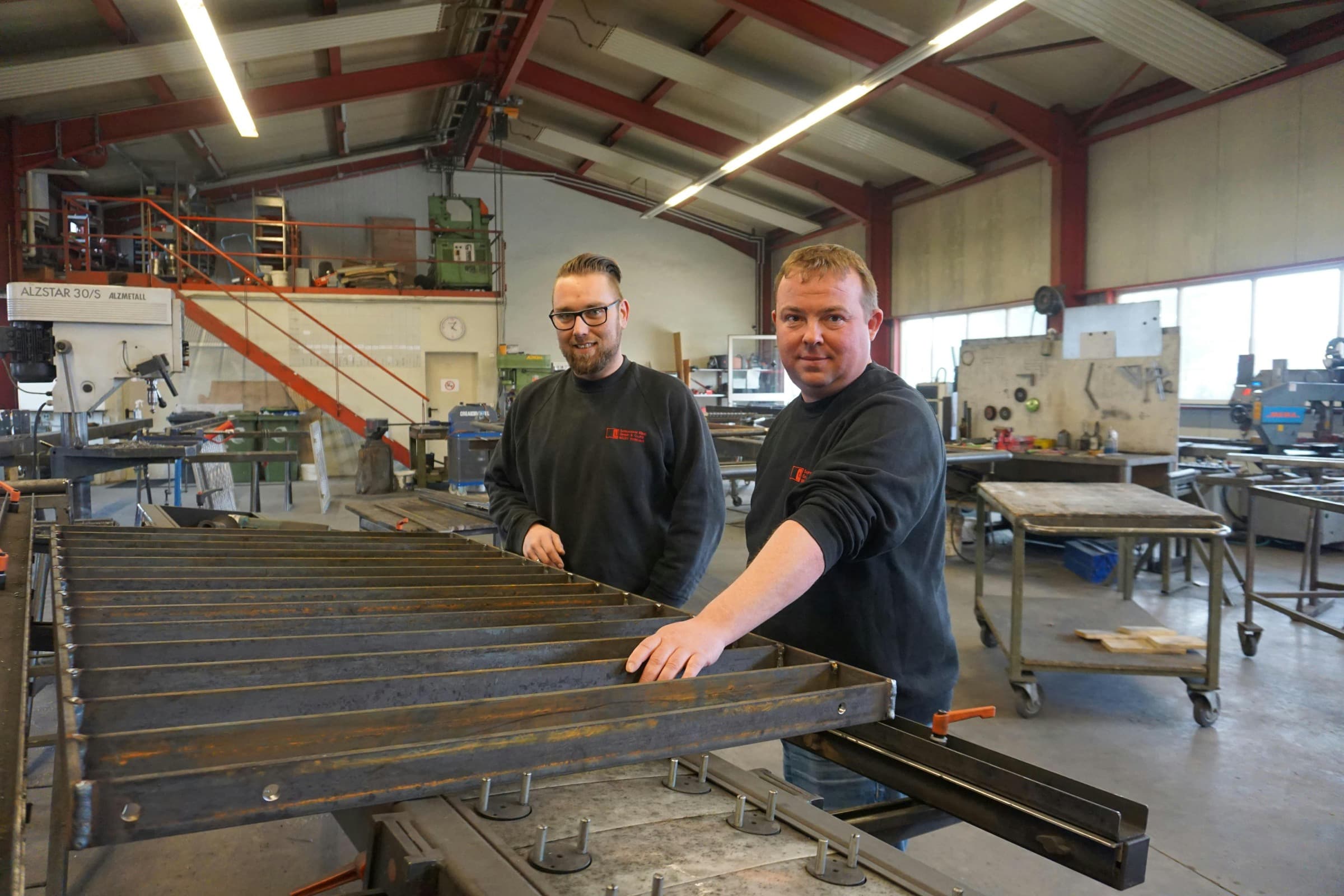 Zwei Metallbauer von Schlosserei Eibel arbeiten gemeinsam an einer Stahlkonstruktion